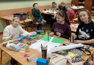 Uczniowie klasy piątej pracują w grupach nad makietami Narnii podczas lekcji języka polskiego.