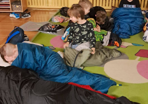 Uczniowie w śpiworach przygotowują się do porannego wstawania.