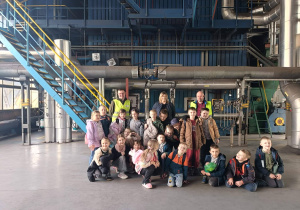 Uczniowie klas 1a i 2a z opiekunami podczas wspólnego zdjęcia w hali Zakładu Energetyki Cieplnej.