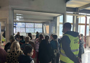Dzieci obserwują sterownię Zakładu Energetyki Cieplnej z ekranami monitorującymi pracę instalacji.