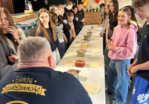 Uczniowie klasy VIIa słuchają instrukcji prowadzącego warsztaty w Pizzerii 105.