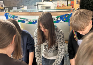 Uczniowie klasy VIIa przygotowują pizzę podczas warsztatów kulinarnych.