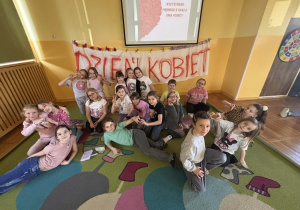 Dziewczynki świętują Dzień Kobiet w świetlicy szkolnej.