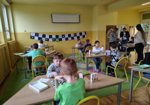 Dzieci grają w warcaby podczas turnieju świetlicowego.