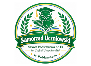 Okrągłe logo Samorządu Uczniowskiego SP nr 13 w Pabianicach. Zielona sowa w birecie nad otwartą książką, otoczona gałązkami laurowymi. Całość w barwach zieleni, żółci i błękitu.
