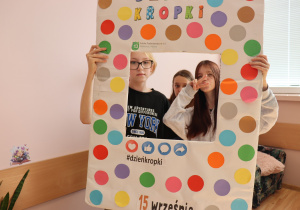 Trzy uczennice klasy 6a z SP13 w Pabianicach pozują w kolorowej ramce z napisem „Dzień Kropki”; jedna z nich pokazuje znak pokoju (V).