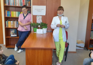 Uczniowie klasy 6a rozmawiają z panią stomatolog i asystentką w szkolnej bibliotece.