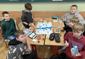 Uczniowie tworzą makietę Narnii z rzeką i śnieżnym krajobrazem, korzystając z materiałów plastycznych.