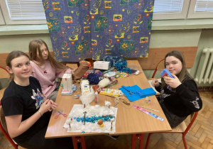 Uczennice przy stoliku prezentują makietę Narnii z rzeką i zimowym krajobrazem w trakcie realizacji projektu.