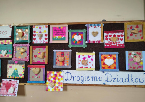 Tablica w świetlicy z wystawą kolorowych prac plastycznych z sercami i napisem „Kochanej Babci”.