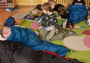 Uczniowie w śpiworach przygotowują się do porannego wstawania.