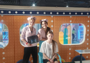 Uczennice w przebraniach medycznych pozują w strefie zabawy.