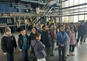 Uczniowie klas 1a i 2a zwiedzają halę techniczną Zakładu Energetyki Cieplnej i oglądają instalacje przemysłowe.