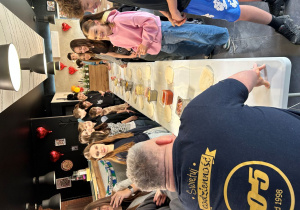 Uczniowie klasy VIIa słuchają instrukcji prowadzącego warsztaty w Pizzerii 105.