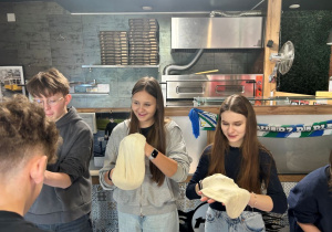 Uczennice klasy VIIa ćwiczą rozciąganie ciasta na pizzę.