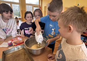 Dzieci miksują składniki na ciasto do babeczek podczas zajęć kulinarnych w świetlicy.