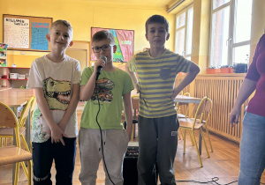 Chłopcy śpiewają podczas karaoke w świetlicy szkolnej.
