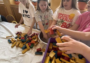 Dzieci czyszczą i układają kolorowe klocki podczas zajęć świetlicowych.