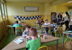 Dzieci grają w warcaby podczas turnieju świetlicowego.