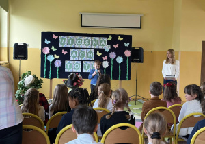 Dziewczynka recytuje wiersz, obok stoi prowadząca konkurs.