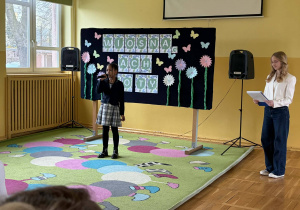 Dziewczynka recytuje wiersz podczas konkursu.