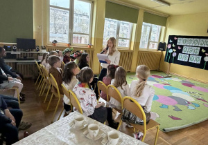 Prowadząca czyta zapowiedź podczas konkursu recytatorskiego.