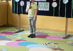 Chłopiec recytuje wiersz podczas konkursu recytatorskiego.