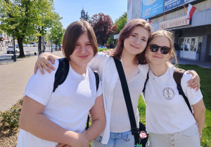 Uczniowie idą razem ulicą i uśmiechają się do zdjęcia.