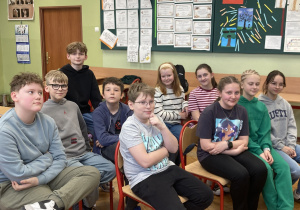 Grupa uczniów siedzi w klasie podczas zajęć teatralnych inspirowanych twórczością polskich bajkopisarzy.