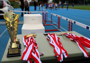 Uczniowie i uczennice podczas zawodów lekkoatletycznych „Zostań Mistrzem” na bieżni MOSiR w Pabianicach – dekoracja medalistów, wręczanie dyplomów i pucharów oraz wspólne zdjęcia uczestników zawodów.