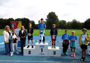 Uczniowie i uczennice podczas zawodów lekkoatletycznych „Zostań Mistrzem” na bieżni MOSiR w Pabianicach – dekoracja medalistów, wręczanie dyplomów i pucharów oraz wspólne zdjęcia uczestników zawodów.