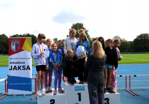 Uczniowie i uczennice podczas zawodów lekkoatletycznych „Zostań Mistrzem” na bieżni MOSiR w Pabianicach – dekoracja medalistów, wręczanie dyplomów i pucharów oraz wspólne zdjęcia uczestników zawodów.