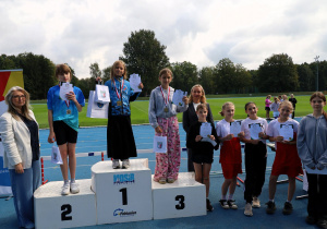 Uczniowie i uczennice podczas zawodów lekkoatletycznych „Zostań Mistrzem” na bieżni MOSiR w Pabianicach – dekoracja medalistów, wręczanie dyplomów i pucharów oraz wspólne zdjęcia uczestników zawodów.