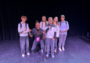 Nick Sinckler pozuje z uczniami klasy 7a ze Szkoły Podstawowej nr 13 w Pabianicach na scenie Teatru Pinokio po spektaklu w ramach festiwalu S·PLOT 2025.