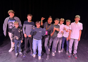 Nick Sinckler pozuje z uczniami klasy 7a ze Szkoły Podstawowej nr 13 w Pabianicach na scenie Teatru Pinokio po spektaklu festiwalu S·PLOT 2025.