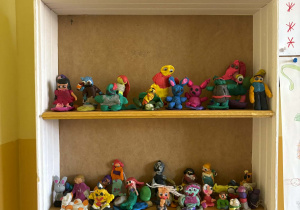 Półka w świetlicy wypełniona plastelinowymi „postaciami z bajek” – kolorowymi figurkami wykonanymi samodzielnie przez dzieci z okazji Światowego Dnia Postaci z Bajek.