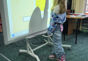 Dziewczynka z klasy 1b wskazuje rozwiązanie zadania matematycznego na tablicy interaktywnej w Pedagogicznej Bibliotece w Pabianicach