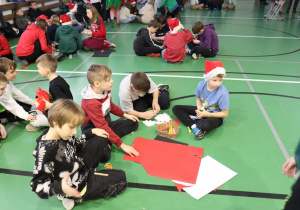 Uczniowie pracują w grupie nad świątecznymi dekoracjami z papieru.