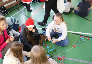 Uczniowie klas I–VI pracują w grupach podczas mikołajkowych zajęć plastycznych.