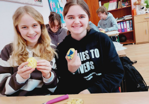 Uczennice trzymają pieczątki z ziemniaków wykonane podczas lekcji „Kamieni na szaniec”.
