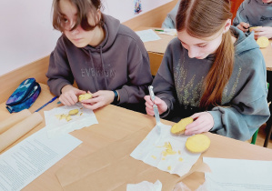 Uczennice wykonują pieczątki z ziemniaków podczas lekcji „Kamieni na szaniec”.
